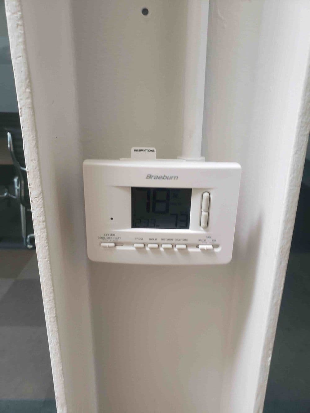 Braeburn digital thermostat displaying a temperature of 73 degrees Fahrenheit.