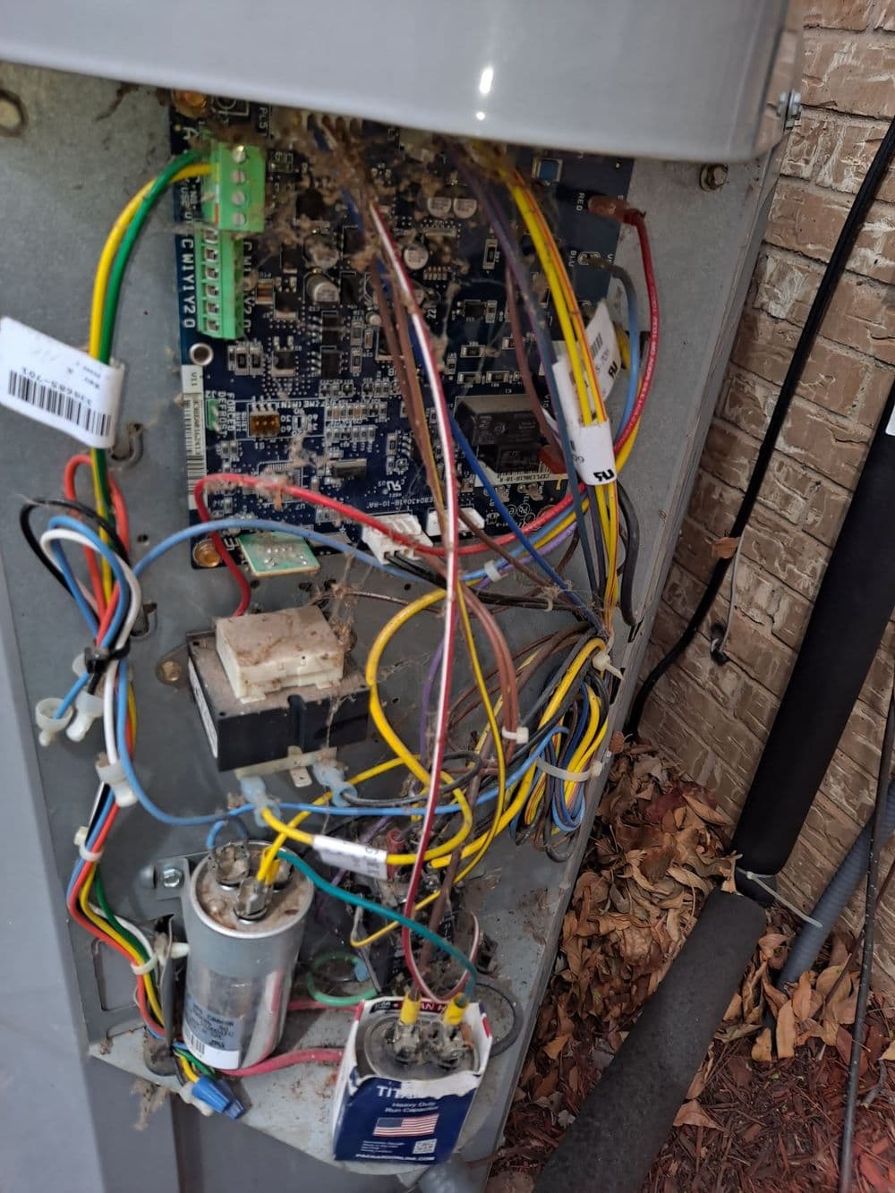 Close-up of a circuit board with colorful wires and components in an outdoor electrical box.