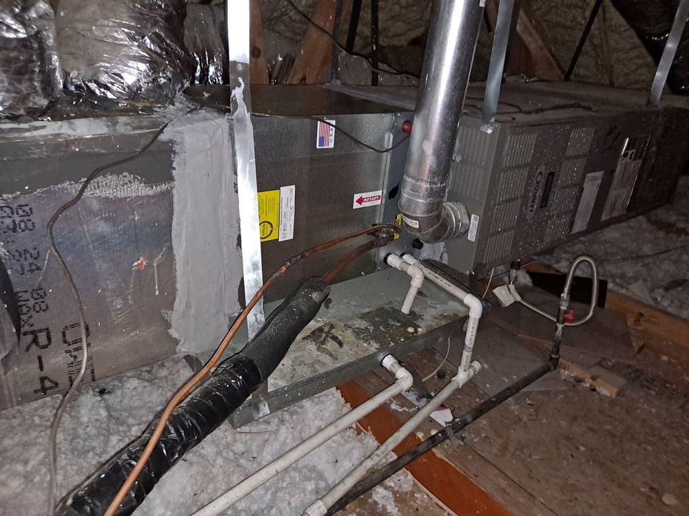HVAC system in attic with ductwork and piping for heating and cooling functionality.