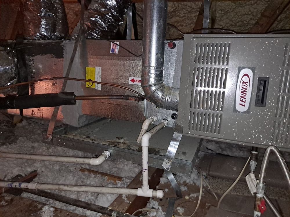 Lennox furnace in attic with ductwork and insulation, ready for residential heating use.