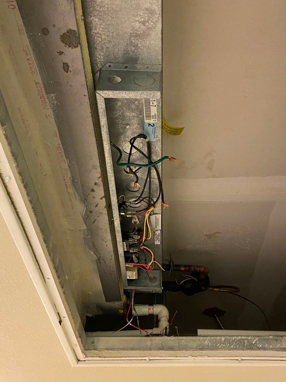 Wiring connections in a ceiling fixture, showing metal channels and various colored wires.